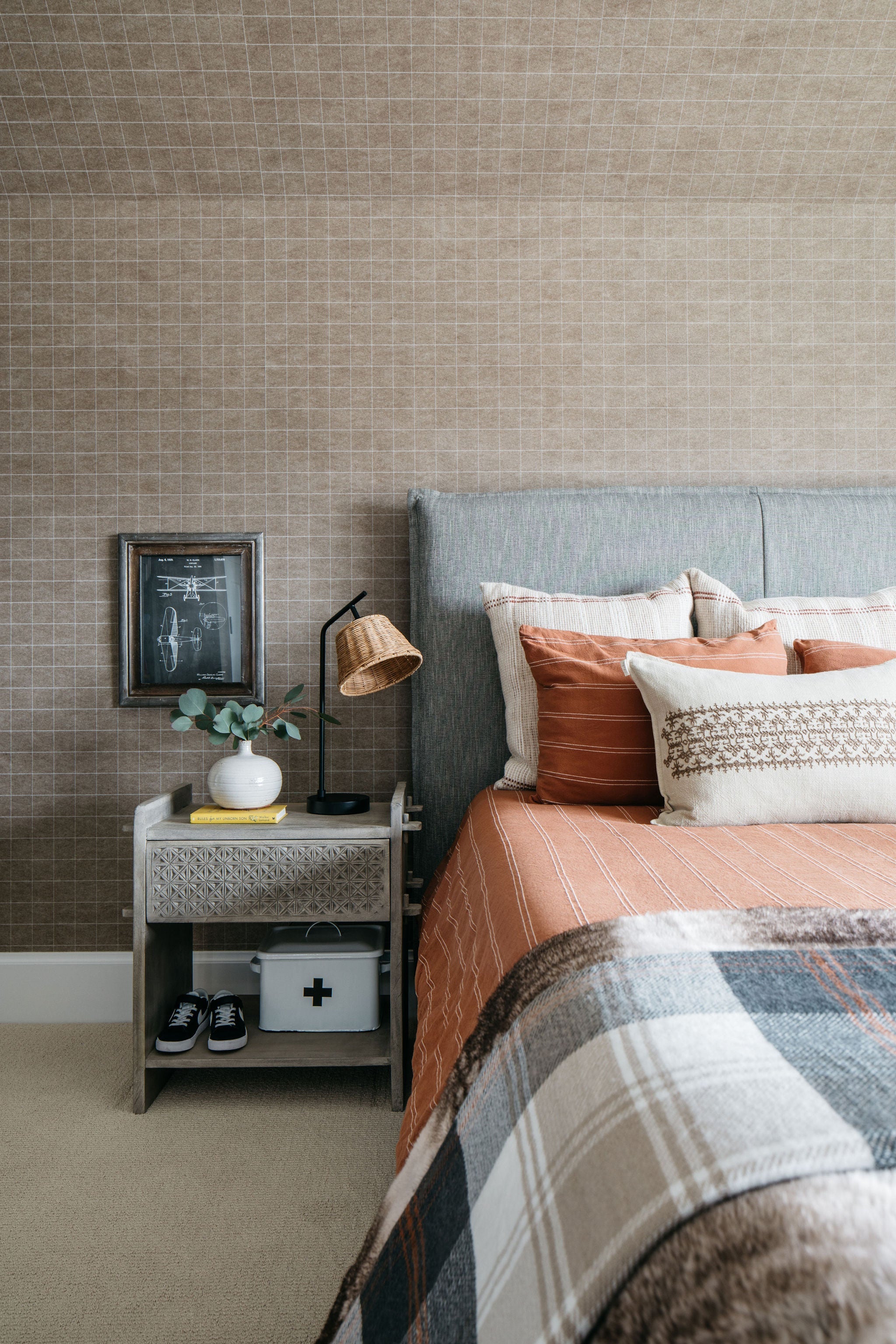 nightstand beside a layered and textured bed